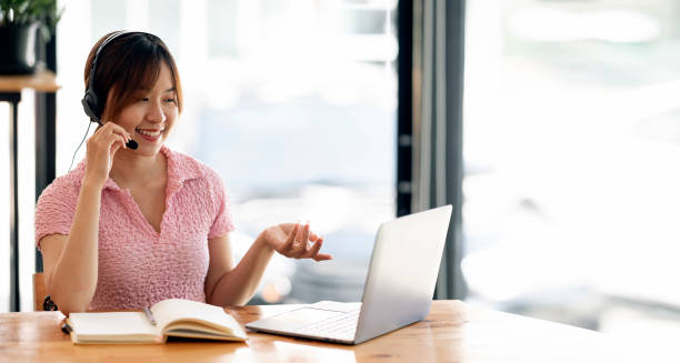istock Young asian woman having video call via laptop computer at co-workspace. 1411630279