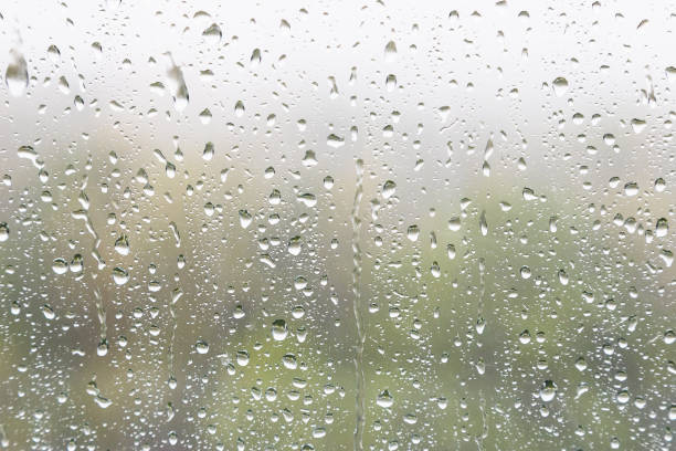 istock rain drops and trickles of rain on window glass 1411630314