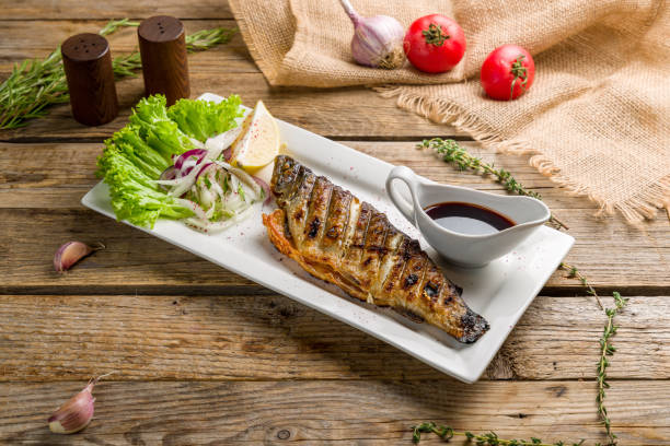 istock grilled trout on a white plate on old wooden table 1411632046