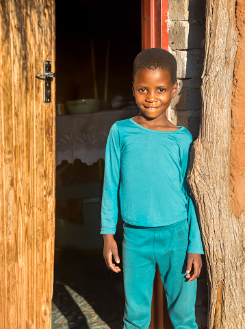 Single African child in front of the kitchen outdoors, village in Botswana