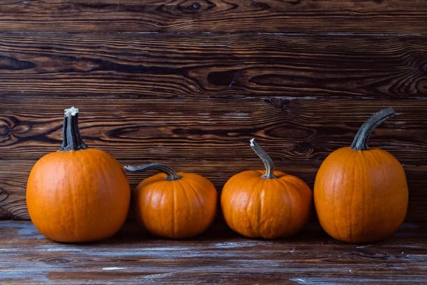 istock Pumpkins on wooden background 1411635335