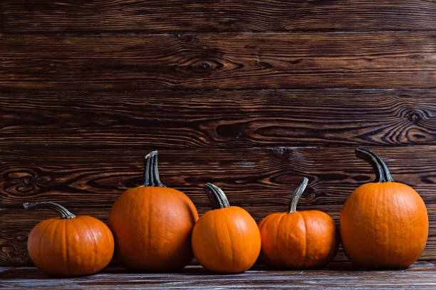 istock Pumpkins on wooden background 1411635471