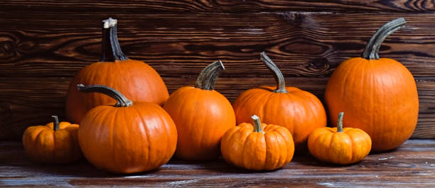 istock Pumpkins on wooden background 1411635547