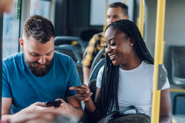 istock Multiracial friends talking while riding a bus in the city and using a smartphone 1411636493