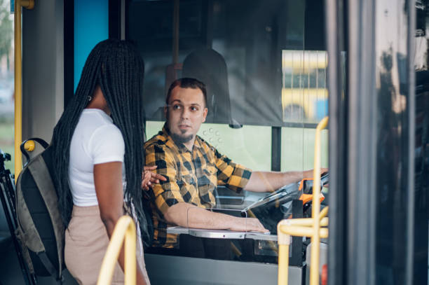 istock Bus driver selling ticket to a female passenger 1411636512