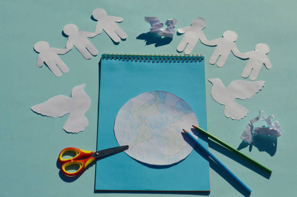 istock On the school table there are accessories for creating a postcard for the International Day of Peace, scissors, pencils, paper for cutting. 1411637764