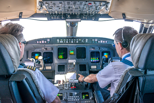 Dakar, Senegal - May 26, 2014: Pilots and cockpit of a commercial airliner on flight to Africa