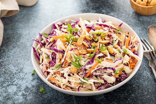 Asian cabbage cole slaw with peanut sauce, roasted peanuts and green onions