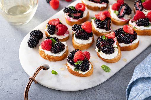 Berry and goat cheese bruschetta with fresh mint and honey