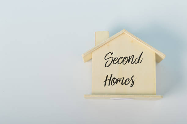 istock Wooden house model with text SECOND HOMES 1411646815