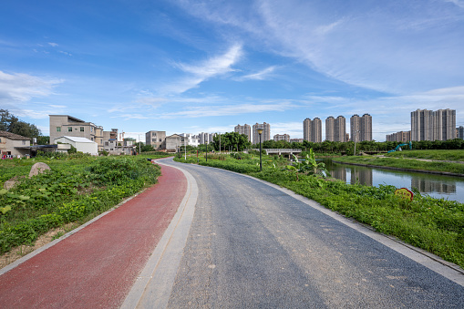 There are trees, residential areas and pedestrian roads in urban green parks