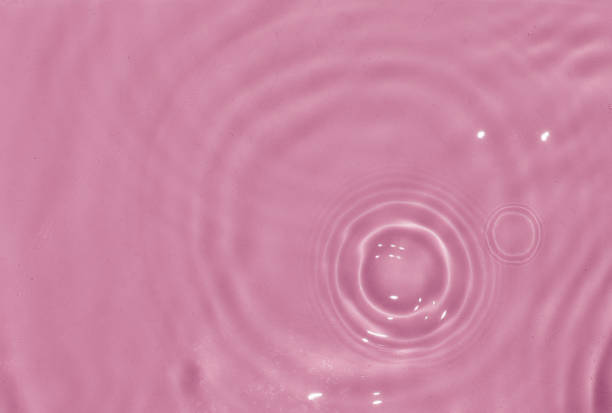 istock Flow of pink water is pouring on rippled water surface. Abstract background. Copy space for your design - stock photo 1411656601