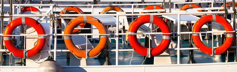 Touristic boats detail, life preserver rings, in  O Grove harbor, Pontevedra province,  Galicia, Spain. Rows of lifeguard floaters hanging from boat deck railings.