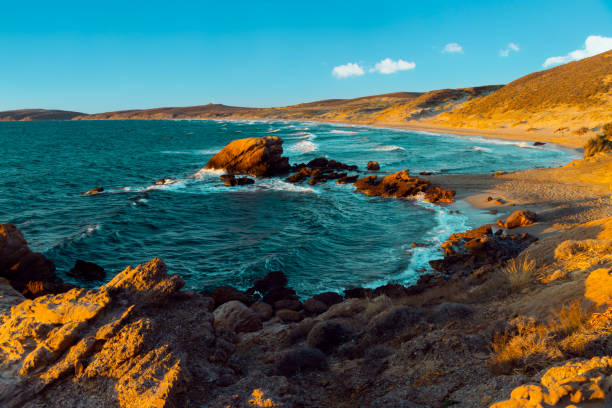 The Red Rock Beach (also called Kokkinovrahos Beach) on Lemnos island in Greece, a popular location for wind and kite surfing. It is known for its red rocky coastline, giving the beach its name.
