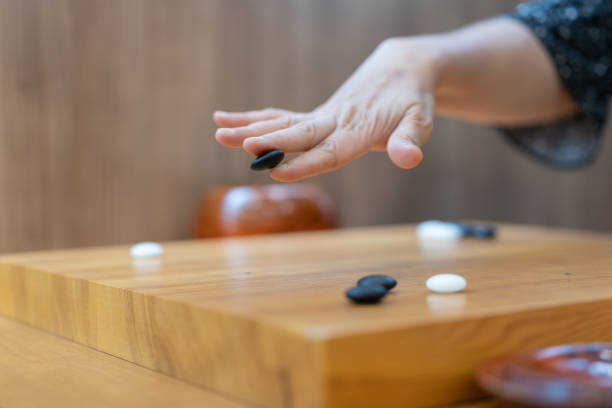 istock close up view of playing black and white stone pieces - Selective focus 1411658816
