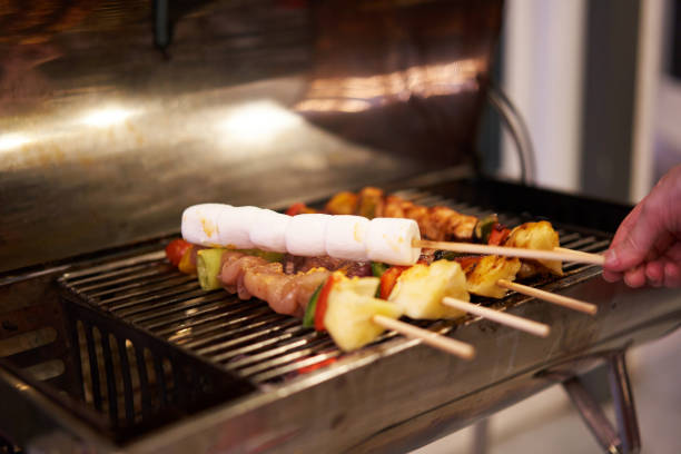 pinchos de malvavisco a la parrilla en barbacoa con varias carnes en una fiesta con la mano borrosa - party barbecue grill burning healthcare and medicine fotografías e imágenes de stock