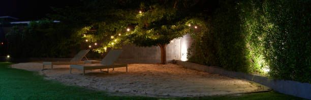 beach chair on sand and lawn under trees at night