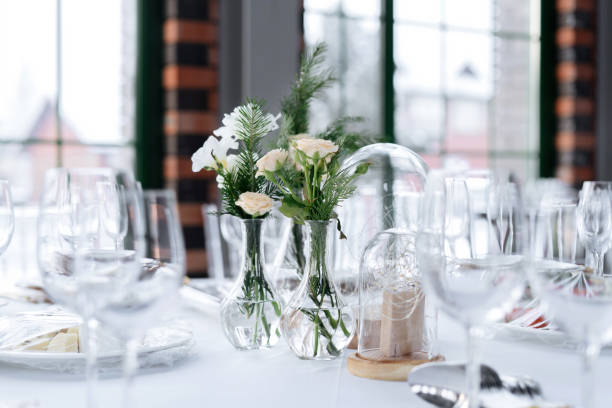 istock Beautifully served wedding table decorated with designer vases with bouquets. 1411660230