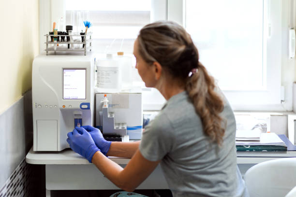 Blood analysis A female veterinarian is performing a blood analysis using advanced technology equipment. human centrifuge stock pictures, royalty-free photos & images