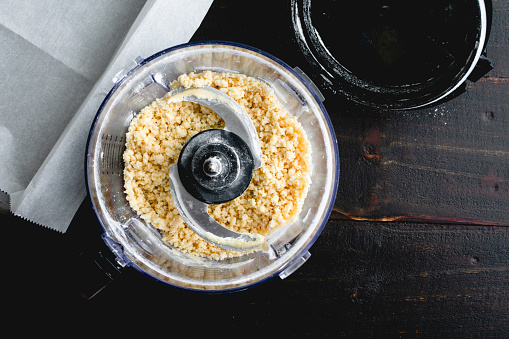 Overhead view of flour, butter, and sugar mixed in a food processor