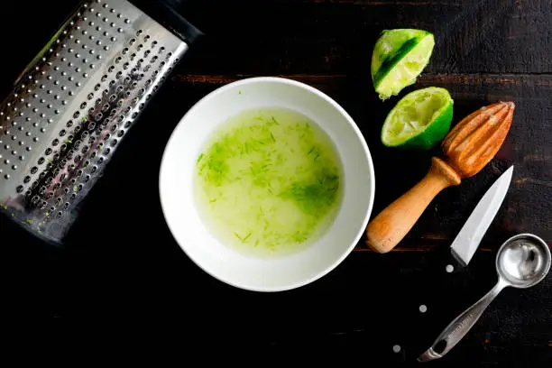 Mixing simple syrup with lime juice and zest to make a cocktail mixer
