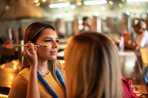Friends painting a face at a bar