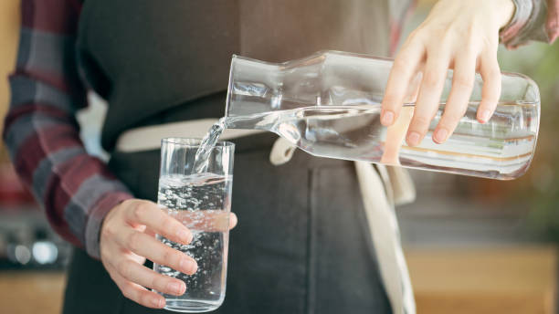 istock Pouring water from a bottle into a glass 1411665436