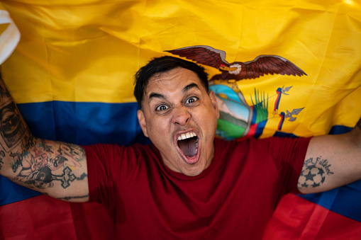 Fan man celebrating winning holding ecuatorian flag