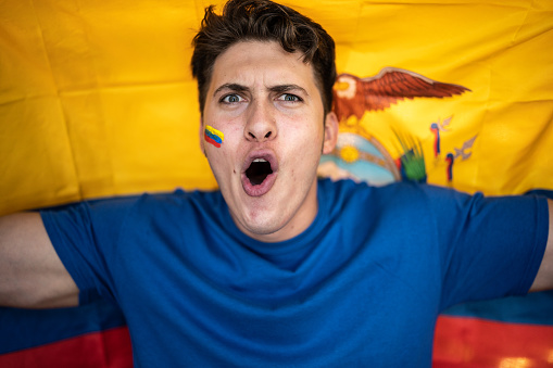 Fan man celebrating winning holding Ecuadorean flag