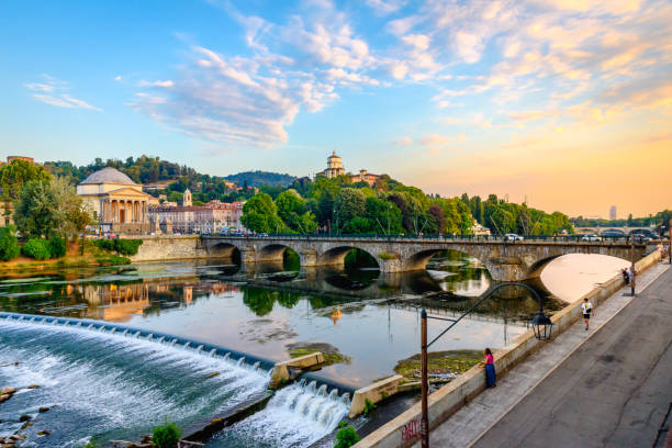 Turin, Italy. Panoramic view at sunset of the Po River, the Church of the Gran Madre, the Church of Monte dei Cappuccini and the Vittorio Emanuel I Bridge. Turin, Italy. Panoramic view at sunset of the Po River, the Church of the Gran Madre, the Church of Monte dei Cappuccini and the Vittorio Emanuel I Bridge. July 13, 2022. turin stock pictures, royalty-free photos & images
