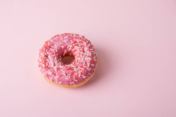 istock pink glazed donut with confectionery sprinkles 1411668757