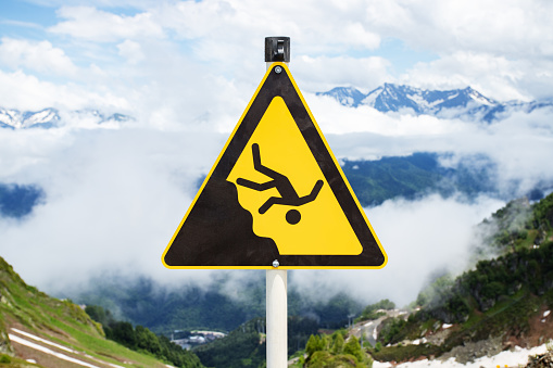 sign man falling from a height, danger of falling from a cliff, mountain collapses, warning of an abyss,