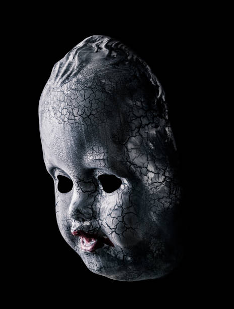 istock Old cracked creepy doll head isolated on black background 1411669678