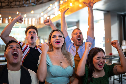 Friends watching and celebrating a sport match