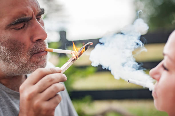 istock Couple smoke together and light cigarettes with fire 1411672845