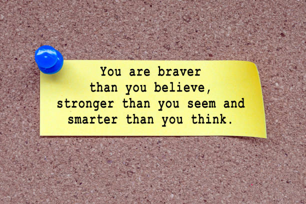 Motivational quote on stick note and pinned to a cork notice board - You are braver than you believe, stronger than you seem and smarter than you think.