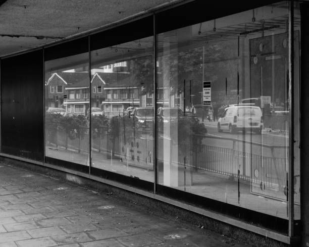 Guildford branch of Debenhams July 2022  A reflection of passing street traffic in the window of closed retail business in the main high street of town shopping centre