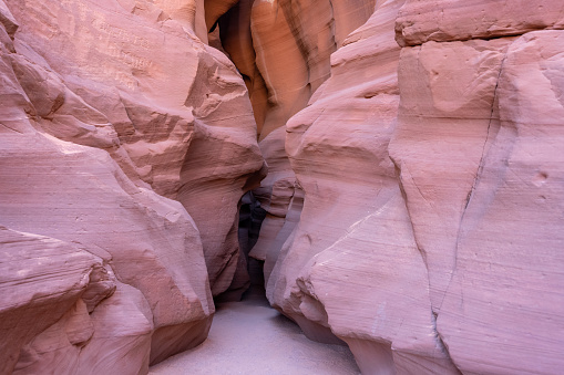 View along a hike inside the deep and narrow Antelope Canyon. This slot canyon is located near the city of Page in Arizona, USA. The walls are shaped like waves.