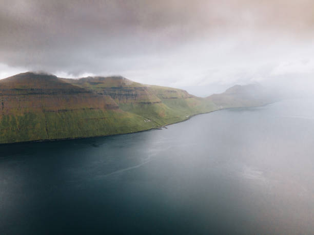 Aerial view of a soccer field surrounded by lake and ocean just outside the small village of Eidi on the north-west tip of Eysturoy on Faroe Islands.