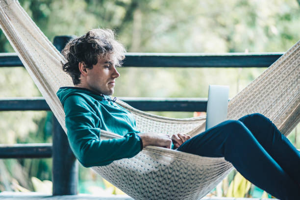 istock Young creative business man works from hammock outdoors 1411683550