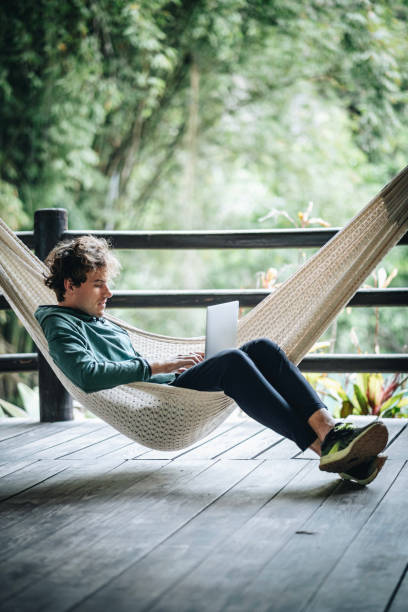 istock Young creative business man works from hammock outdoors 1411683573