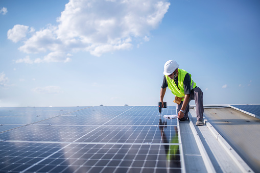 Man on roof installing solar panel system.