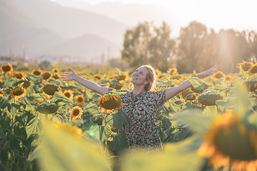 Woman enjoys in sunflower field