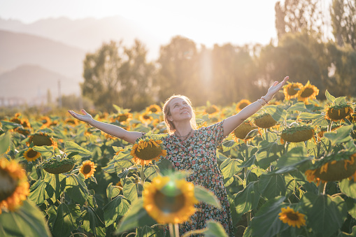Woman enjoys in sunflower field