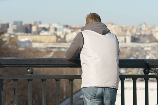 istock Handsome man stansing on the bridge, back view 1411695594