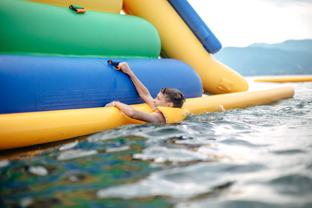 Kid having fun in Water Park Boy enjoying in Water Park jumping in water top of water slide photos stock pictures, royalty-free photos & images