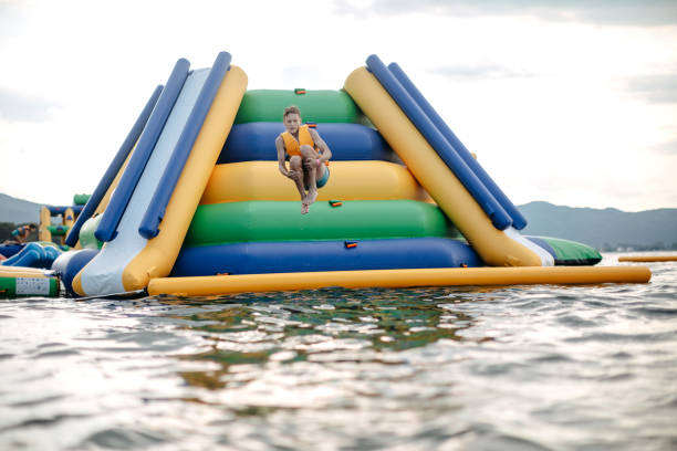 Kid having fun in Water Park Boy enjoying in Water park jumping in water top of water slide photos stock pictures, royalty-free photos & images