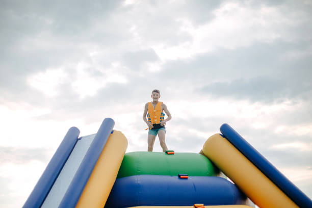 Kid having fun in Water Park Boy enjoying in Water park jumping in water top of water slide photos stock pictures, royalty-free photos & images