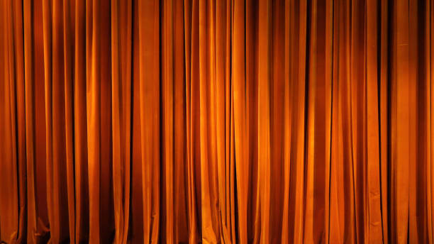 The yellow curtain. Theatrical scenes with light from the spotlights in the closed position The yellow curtain. Theatrical scenes with light from the spotlights in the closed position. intermission stock pictures, royalty-free photos & images