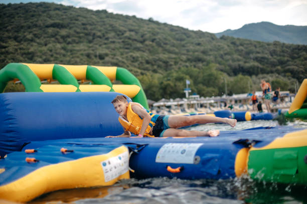Kid having fun in Water Park Boy enjoying in Water park on slippery surface top of water slide photos stock pictures, royalty-free photos & images